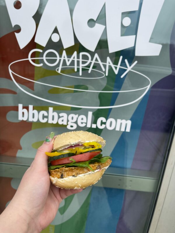 close up of a veg burger and bbcbagel.com in background